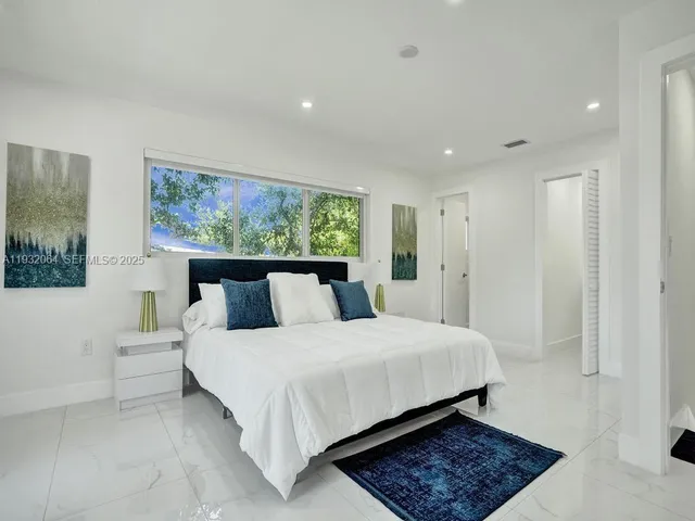 a large bedroom with a bed and a window