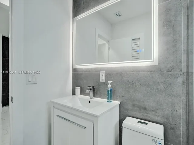 a bathroom with a sink a toilet and a mirror