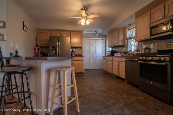 a kitchen with stainless steel appliances kitchen island granite countertop a stove top oven a sink a dining table and chairs