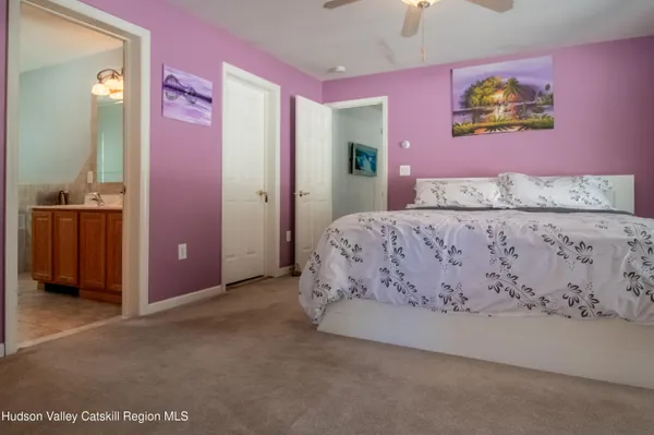 a bedroom with a bed and a painting on the wall