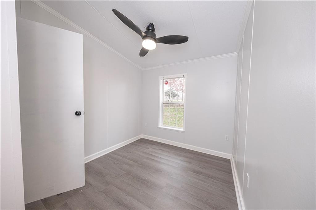 111 Leopard Road Evans City, PA 16033 - Photo 23 of 43 an empty room with wooden floor fan and windows