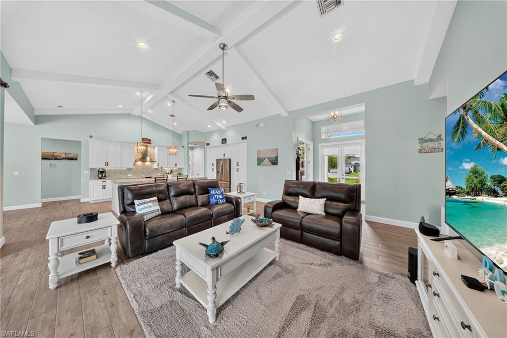 37 Johnnycake Drive Naples, FL 34110 - Photo 24 of 33 Dedicated laundry space featuring wood-finish flooring, a tall window, a substantial countertop, and white cabinetry