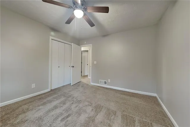 an empty room with chandelier fan