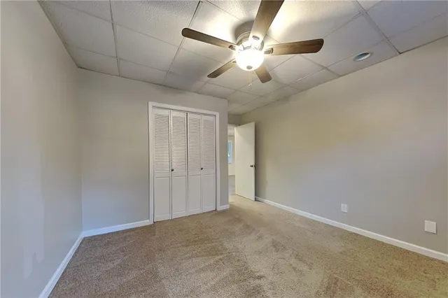 en empty room with ceiling fan and window