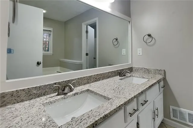 a bathroom with a granite countertop sink and a mirror