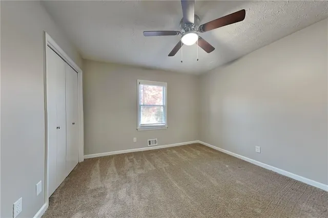an empty room with a window and a fan