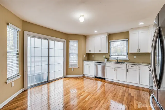 a large kitchen with cabinets wooden floor and a sink