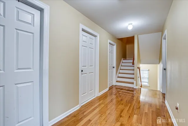 a view of a hallway with wooden floor and entryway