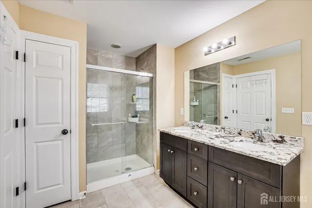 a bathroom with a granite countertop sink mirror and shower