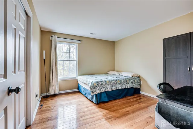 a bedroom with a bed and wooden floor