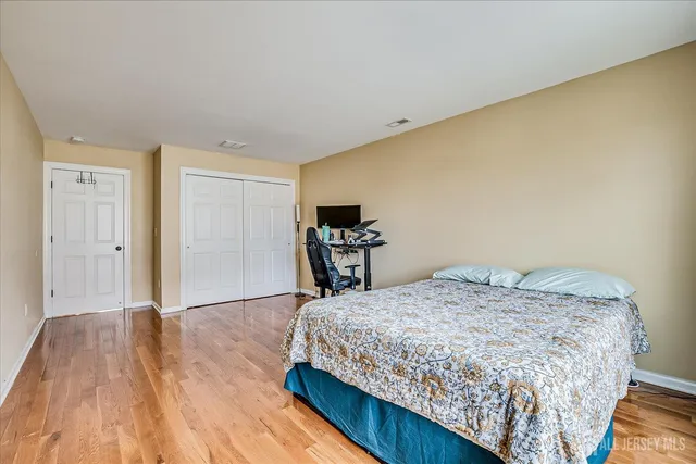 a bedroom with a bed and wooden floor