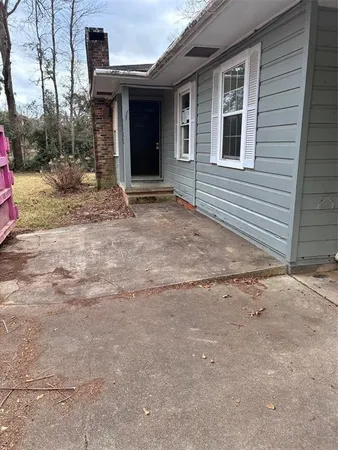 a view of house with backyard and trees in the background