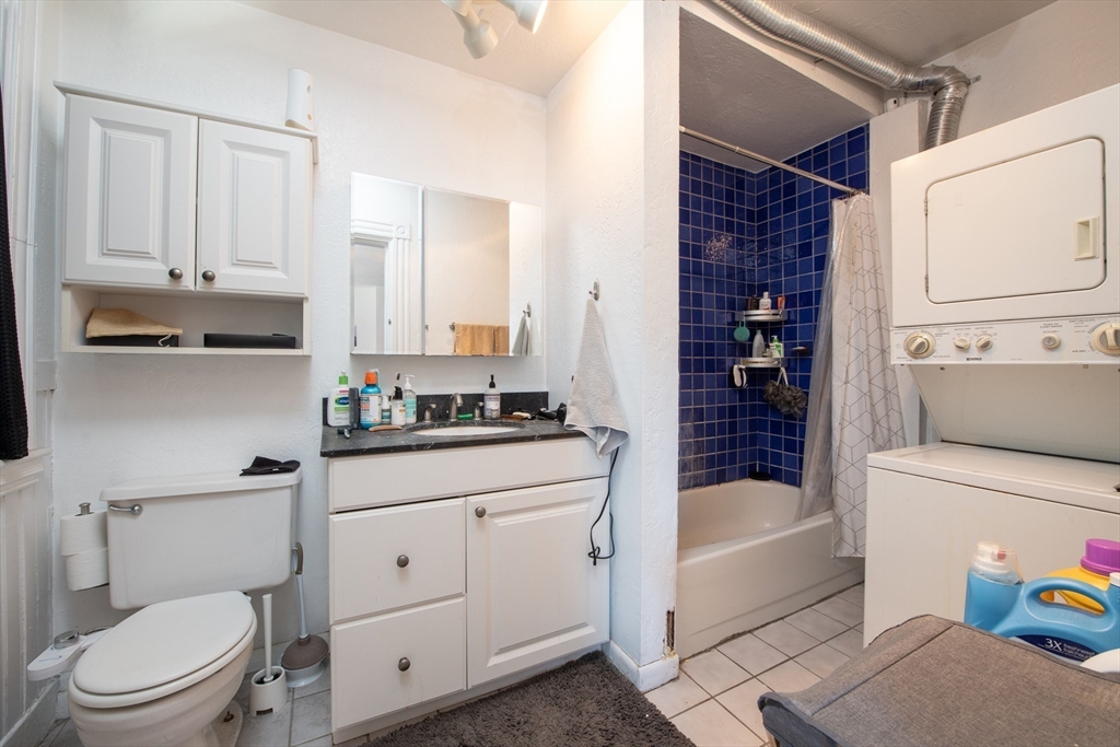918 Beacon Street, Unit 3 Boston, MA 02215 - Photo 10 of 19 a bathroom with a granite countertop sink a toilet and bathtub