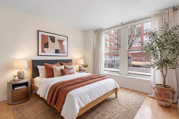 a bedroom with a bed and a large window