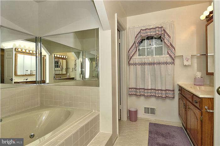 14571 Cutstone Way Silver Spring, MD 20905 - Photo 17 of 30 a bathroom with a tub sink and mirror