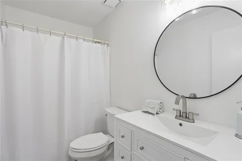 a bathroom with a sink a toilet and a mirror