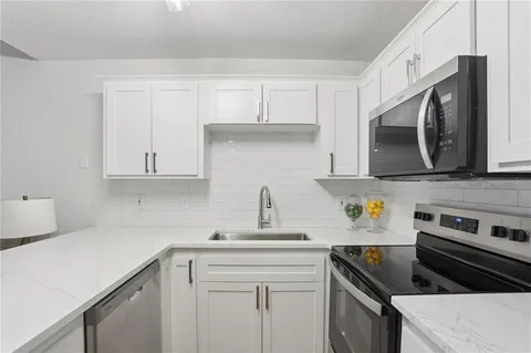 a kitchen with cabinets stainless steel appliances and a sink