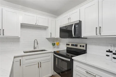 a kitchen with stainless steel appliances a stove microwave and cabinets