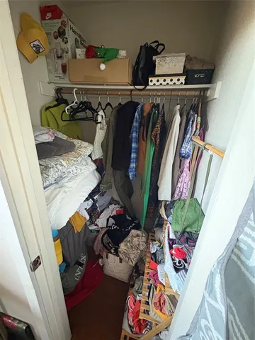 a view of a hallway to a closet and a chandelier fan