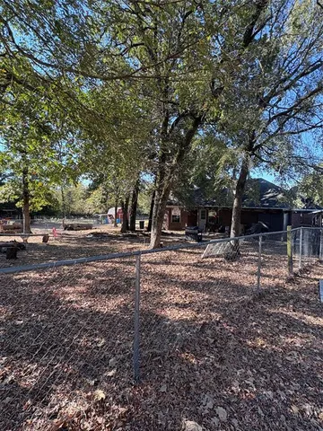 a view of dirt yard with a large tree