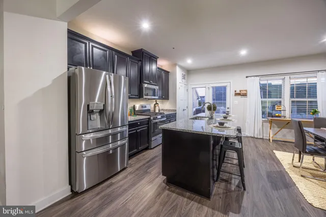 a kitchen with kitchen island white cabinets and stainless steel appliances