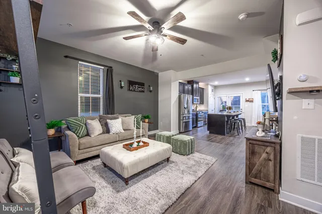 a living room with furniture and a wooden floor