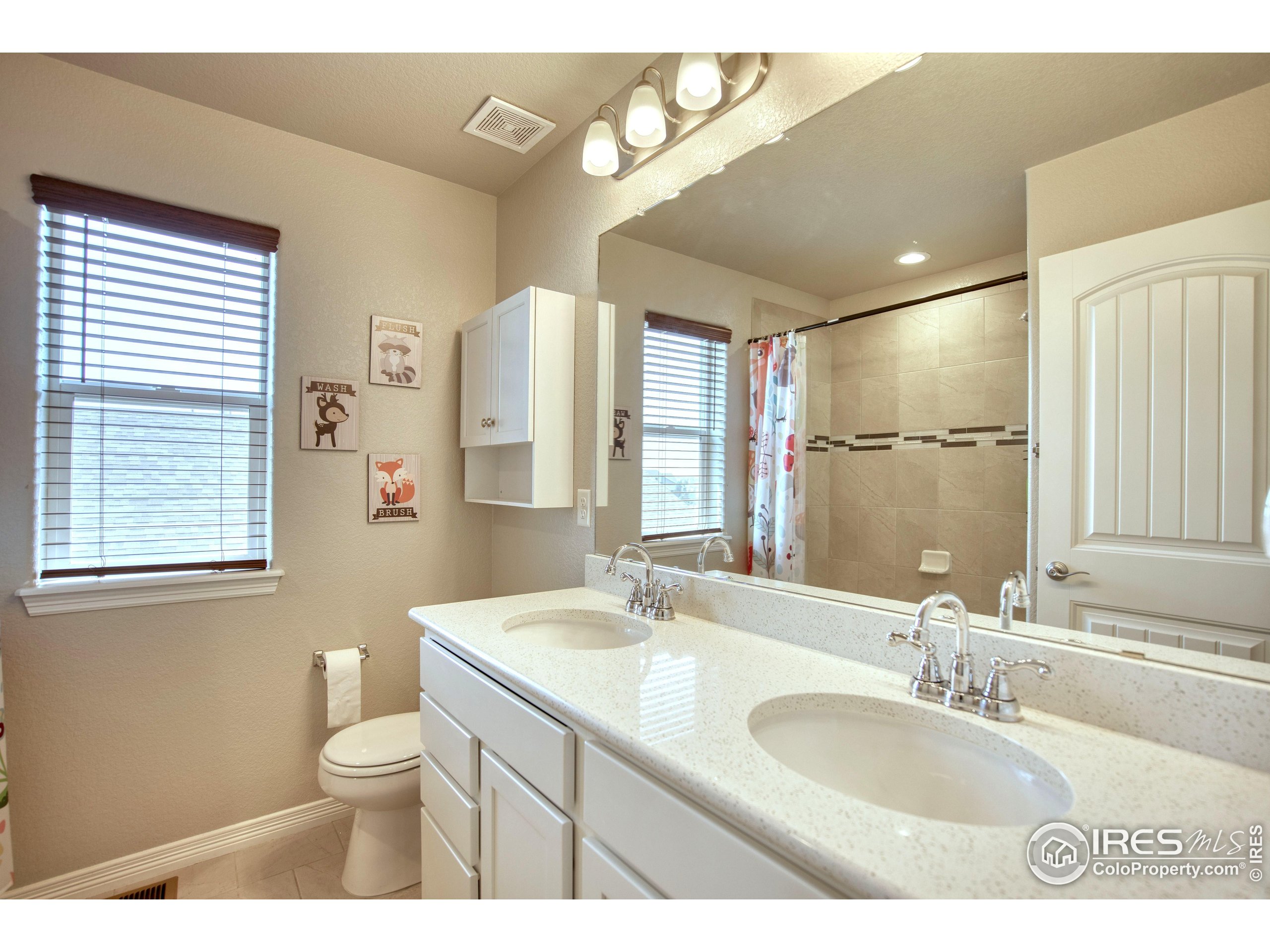 1866 Egnar Street Loveland, CO 80538 - Photo 20 of 28 a bathroom with a granite countertop sink mirror vanity and a toilet