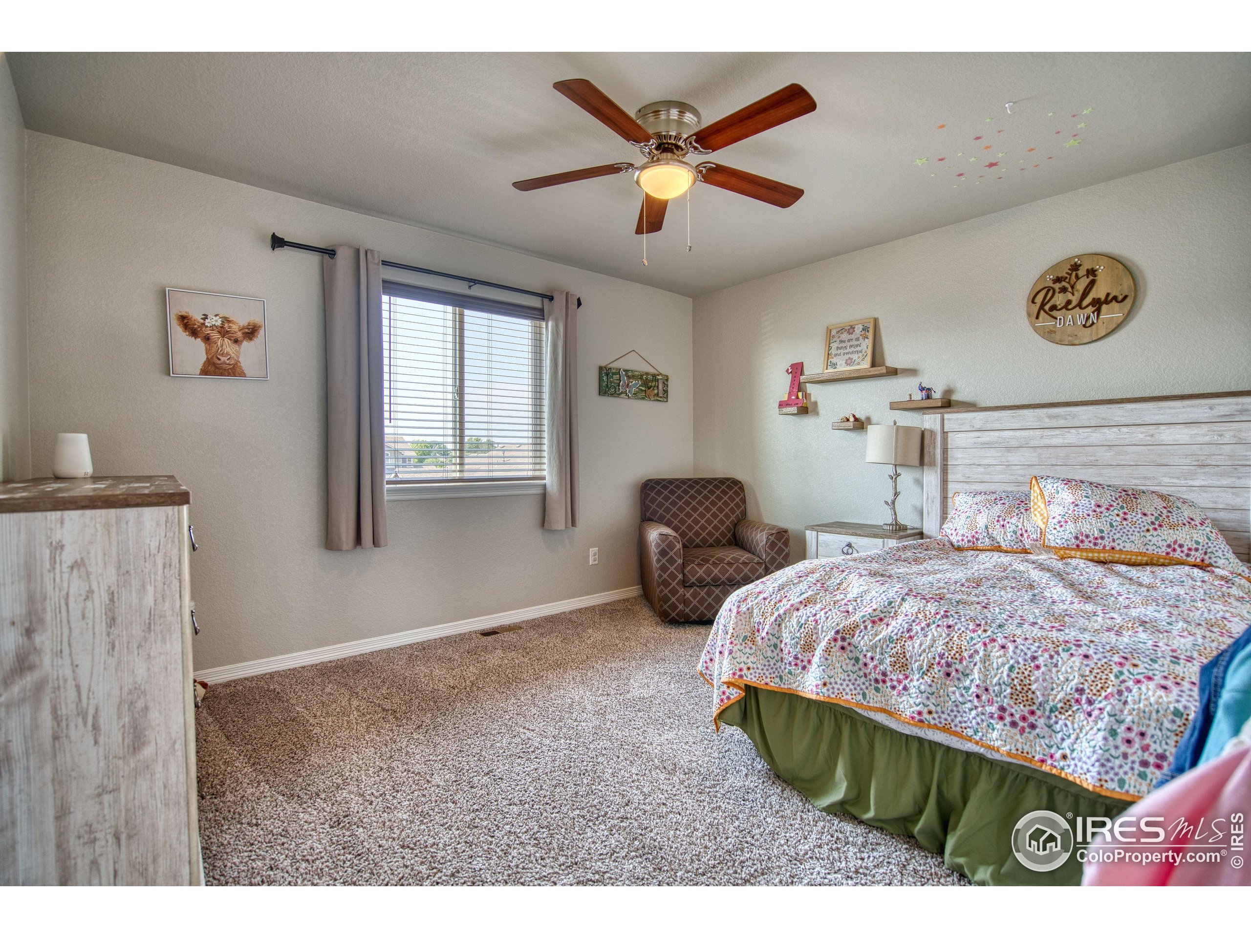 1866 Egnar Street Loveland, CO 80538 - Photo 21 of 28 a bedroom with a bed and a chandelier