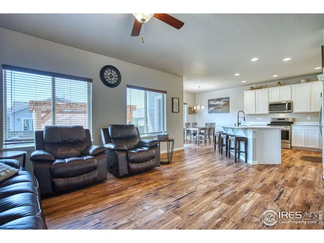 a living room with furniture wooden floor and a kitchen