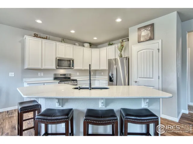 a kitchen with granite countertop a refrigerator stove top oven with a sink and dishwasher