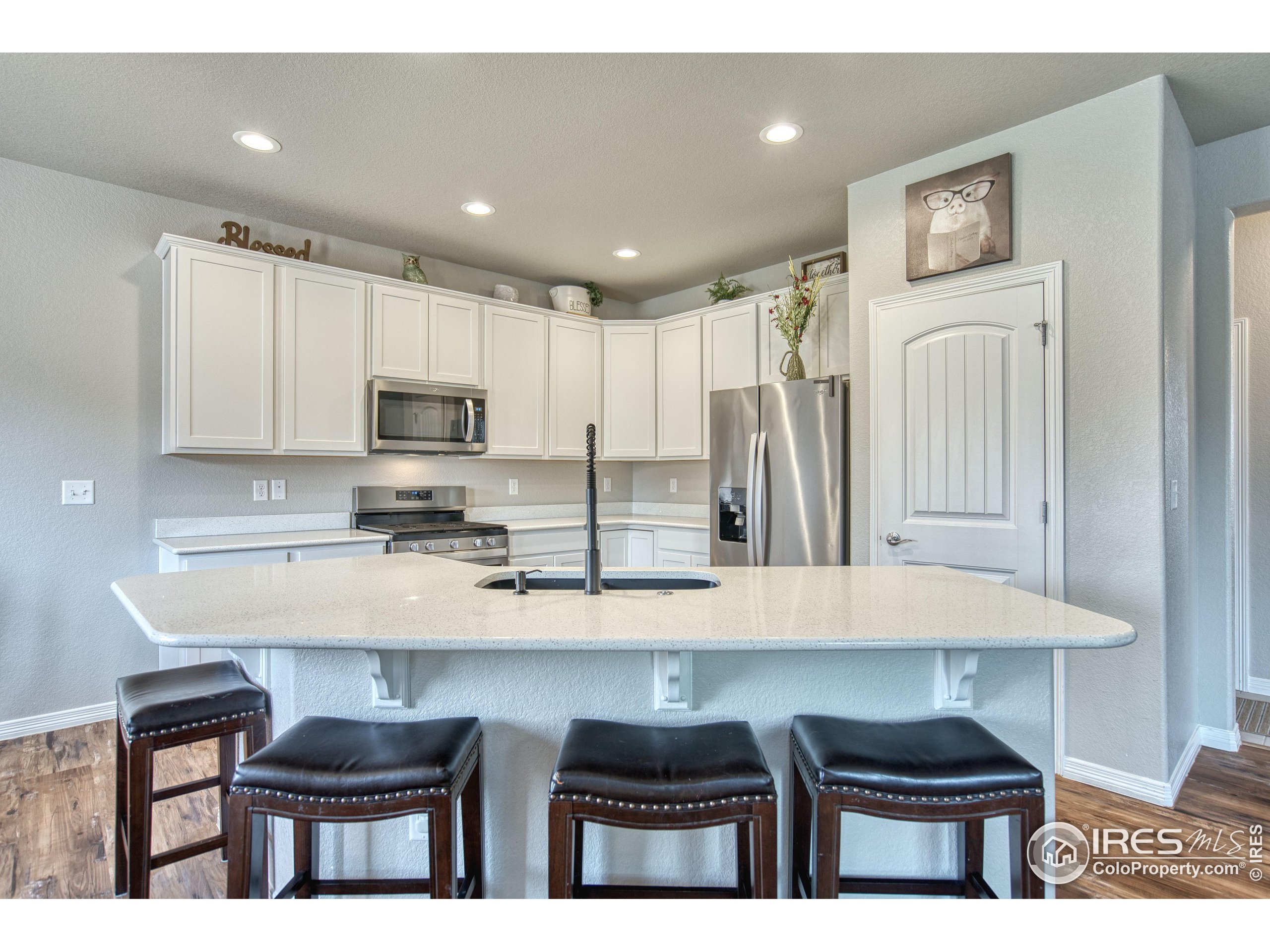 1866 Egnar Street Loveland, CO 80538 - Photo 5 of 28 a kitchen with granite countertop a refrigerator stove top oven with a sink and dishwasher