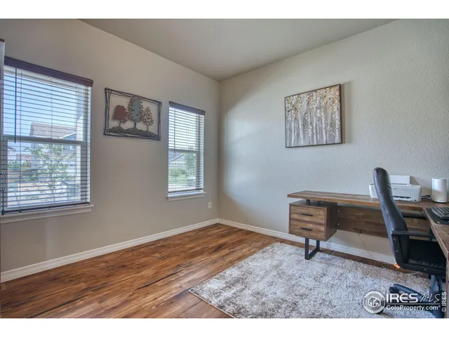 a workspace room with wooden floor furniture and a window