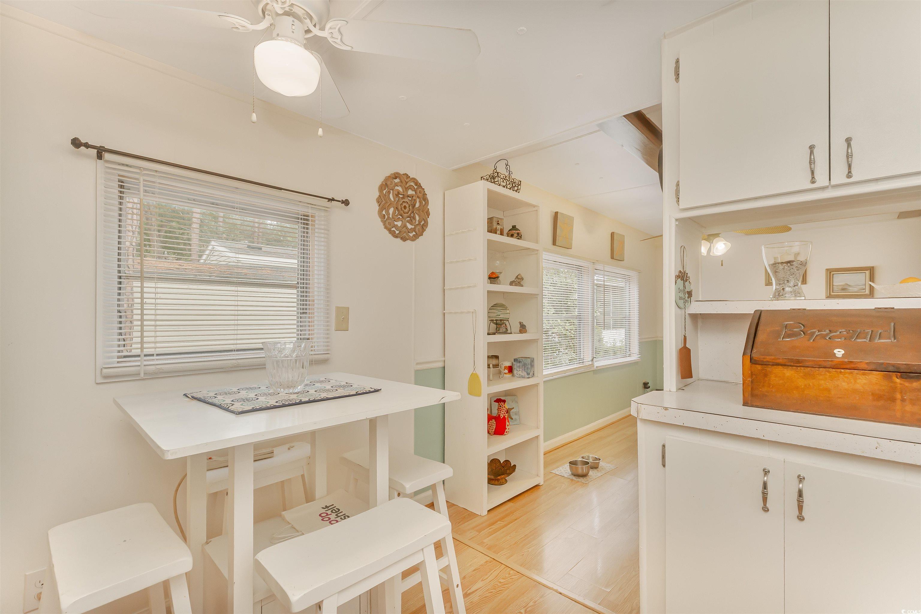 382 West Canal Street Murrells Inlet, SC 29576 - Photo 17 of 38 Kitchen with white cabinetry, light hardwood / wood-style floors, a kitchen breakfast bar, and ceiling fan