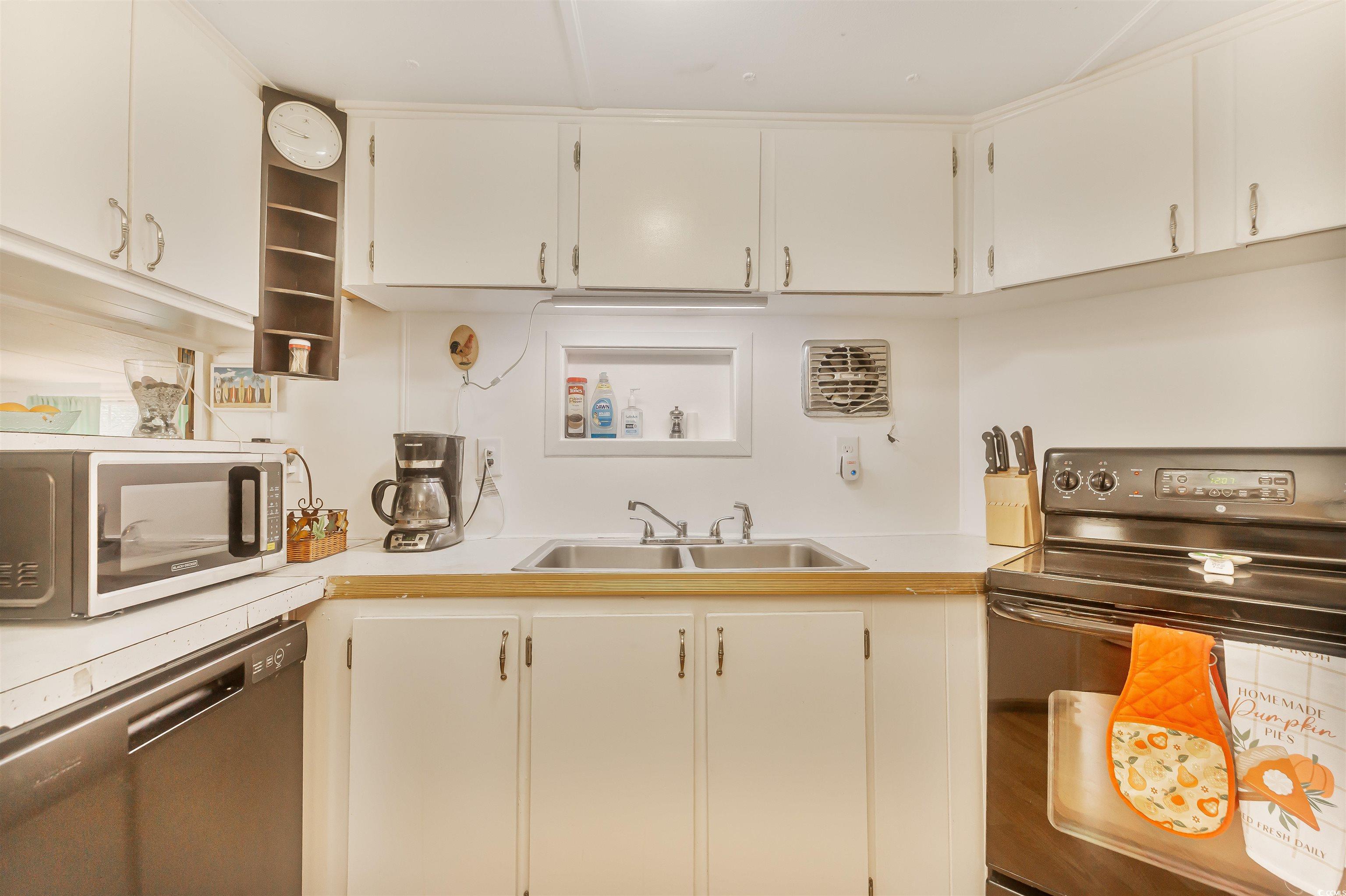 382 West Canal Street Murrells Inlet, SC 29576 - Photo 20 of 38 Kitchen featuring white cabinetry, appliances with stainless steel finishes, and sink