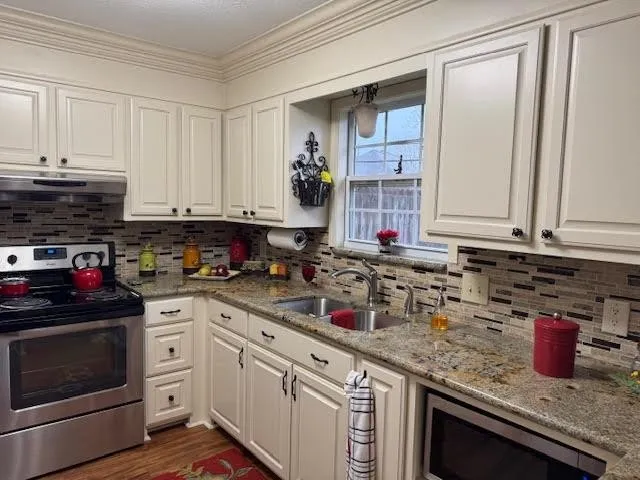 a kitchen with stainless steel appliances granite countertop a sink stove and cabinets