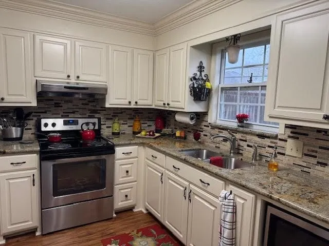 a kitchen with stainless steel appliances granite countertop a stove and cabinets