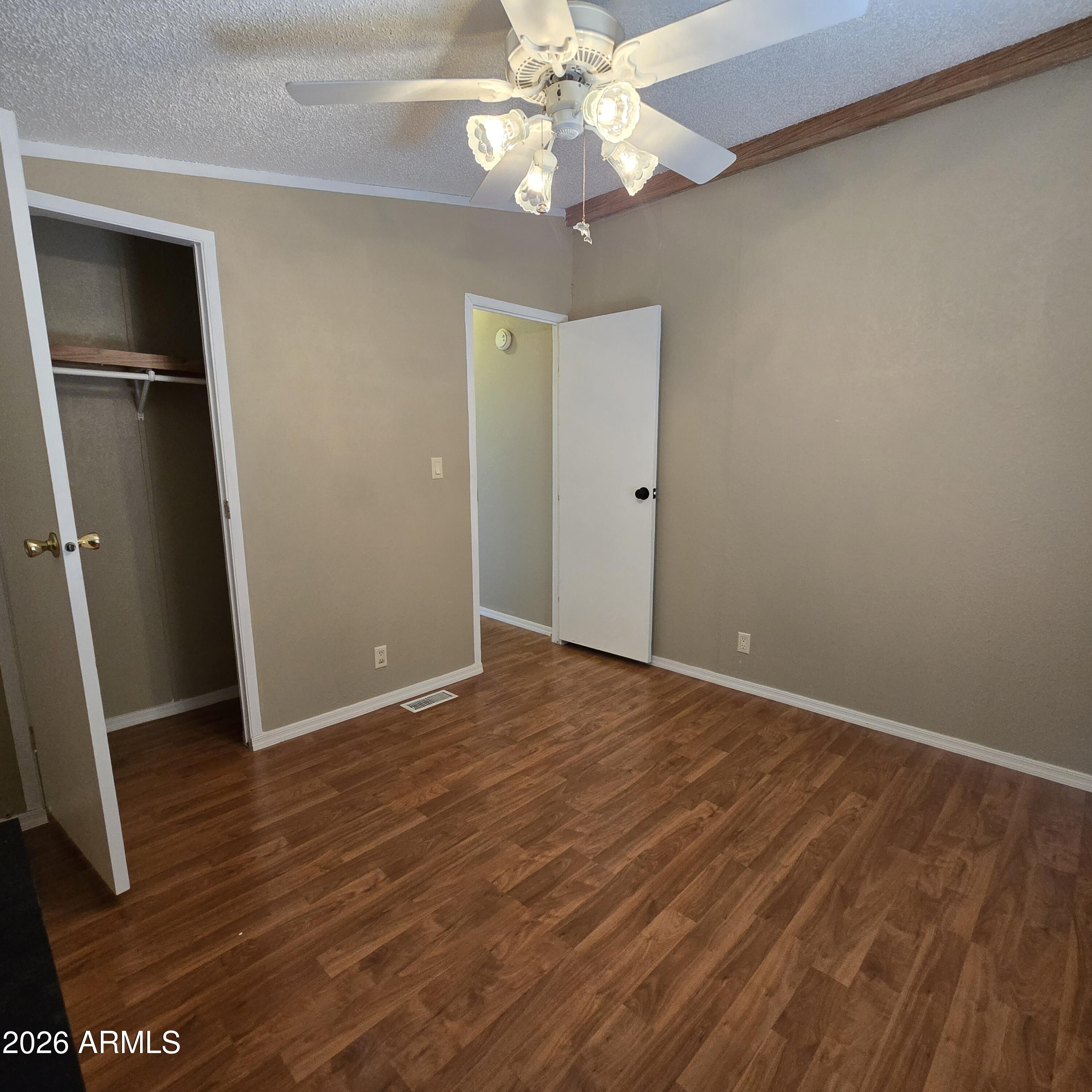 205 West Bell Road, Unit 131 Phoenix, AZ 85023 - Photo 20 of 47 an empty room with wooden floor and ceiling fan