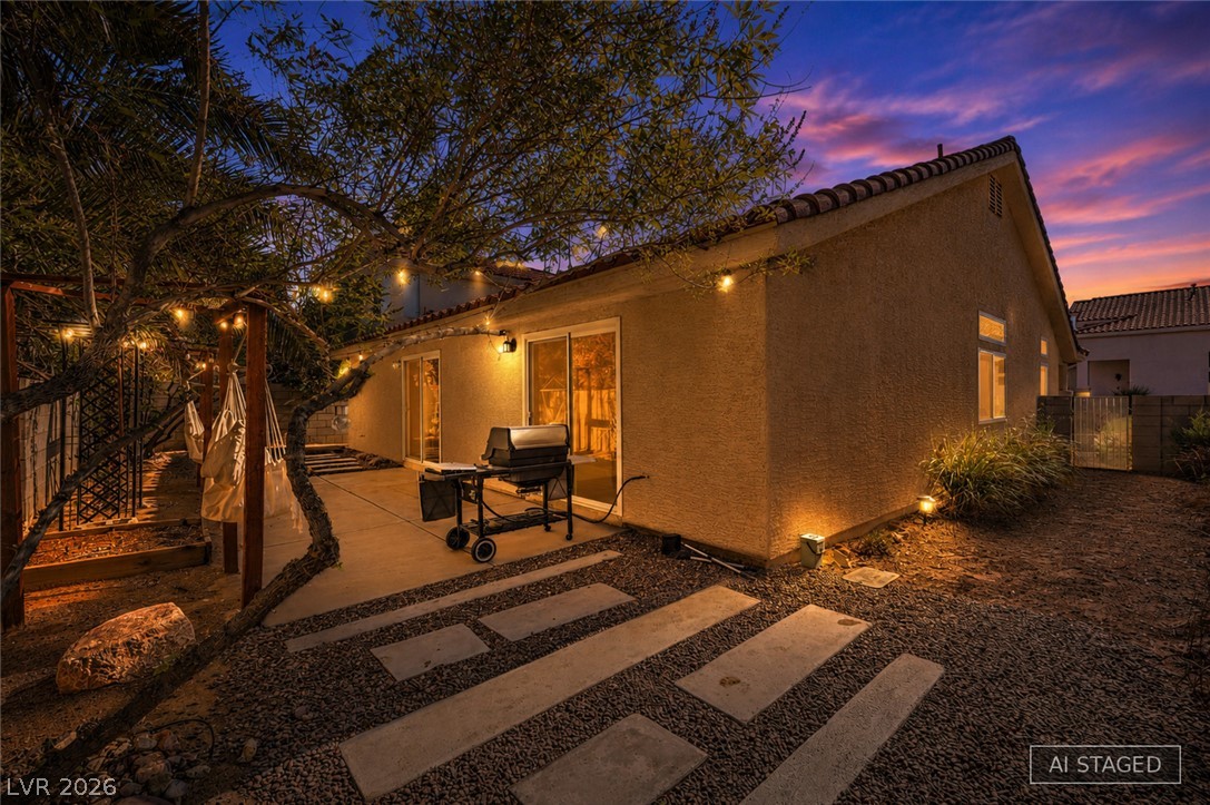 1900 Cardinal Point Street Henderson, NV 89012 - Photo 7 of 32 An inviting backyard patio with string lights, a grill, and hammocks offers the perfect setting for twilight relaxation.