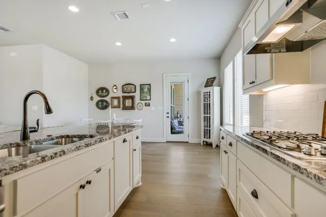 a kitchen with granite countertop a stove and a sink
