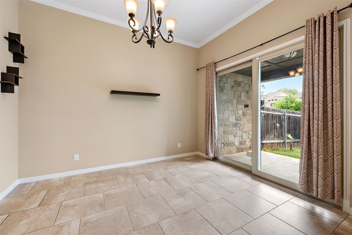 2000 Manada Trail Leander, TX 78641 - Photo 16 of 36 Step into this luminous dining space, featuring a grand chandelier and convenient patio access.
