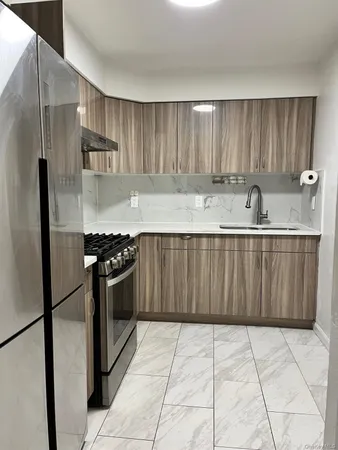 a kitchen with stainless steel appliances granite countertop a refrigerator and a sink