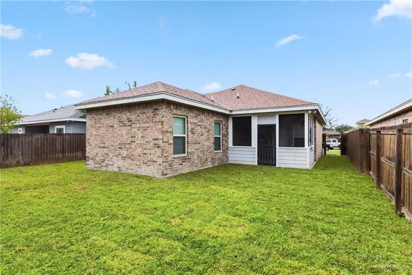 a view of a backyard with brick wall and wooden fence