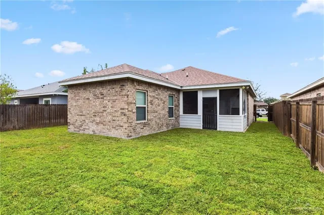 a view of a backyard with brick wall and wooden fence