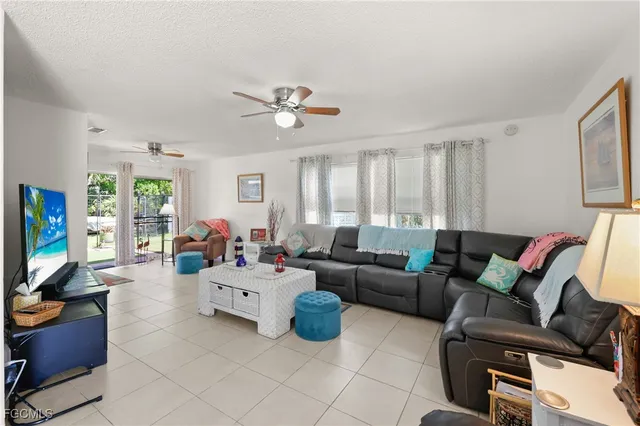 a living room with furniture a flat screen tv and a window