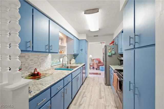 a kitchen with stainless steel appliances granite countertop a refrigerator and a sink