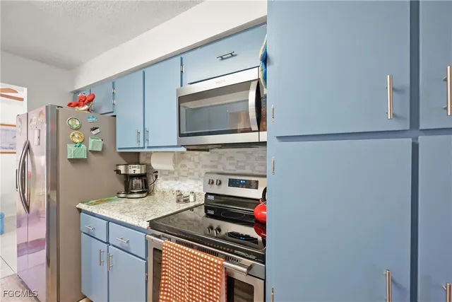 a kitchen with a refrigerator and a stove top oven