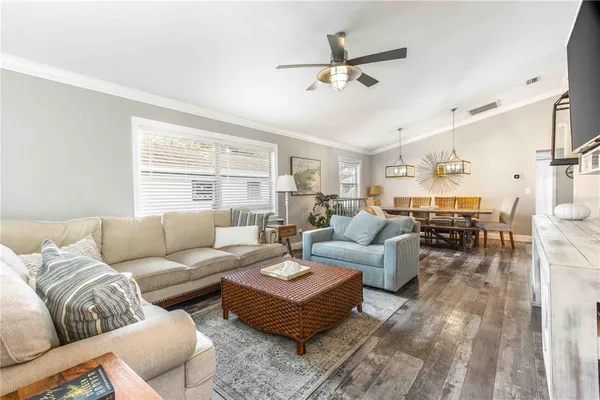 a kitchen with stainless steel appliances granite countertop a sink dishwasher cabinets a dining table and chairs with wooden floor