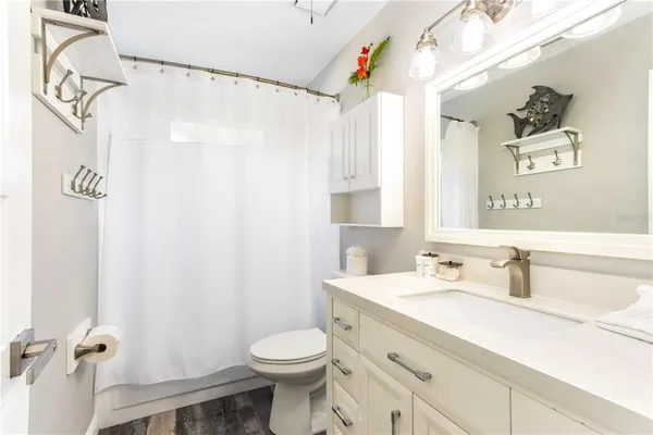 a spacious bedroom with a bed and wooden floor