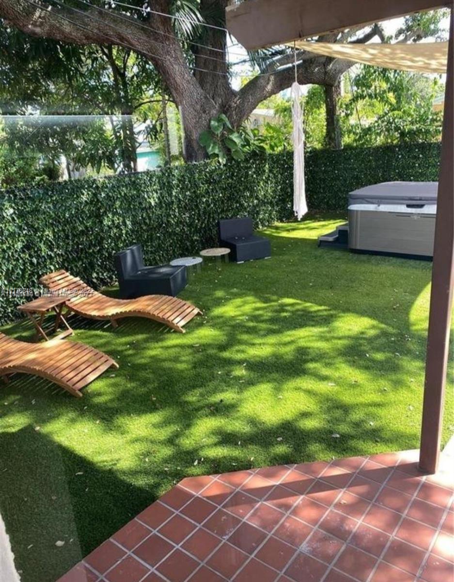 6 Northeast 50th Street Miami, FL 33137 - Photo 14 of 14 a view of a backyard with couches under an umbrella