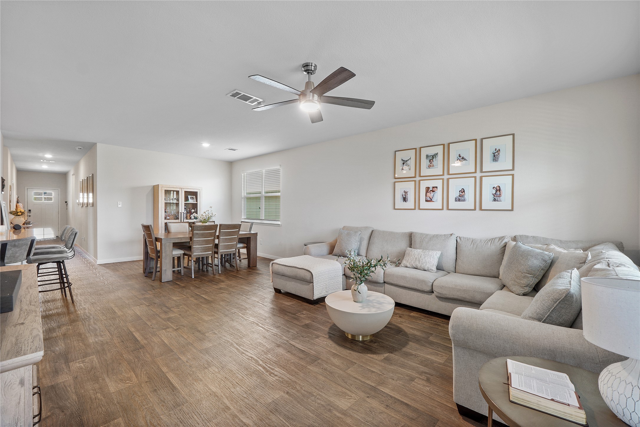217 Evergreen Sumac Loop Kyle, TX 78640 - Photo 7 of 20 Sun-filled open-concept living space boasts gleaming hardwood-style flooring and modern recessed lighting.